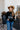 Teen-aged girl standing with cowboy hat on wearing black crewneck with the Royal Family Farms Crown Log
